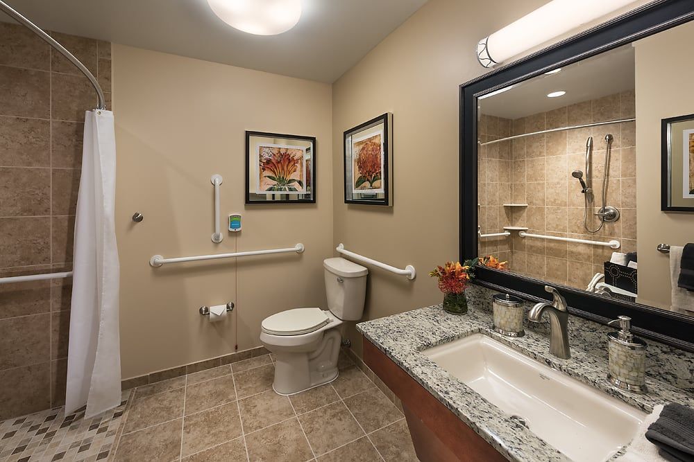 A modern bathroom with accessibility features, including grab bars and a spacious layout.