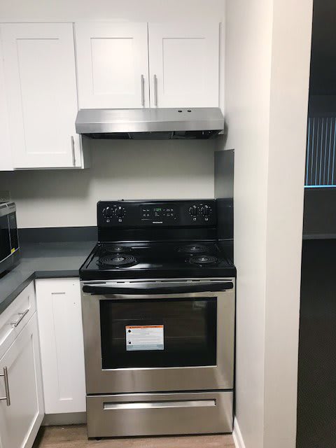 A modern kitchen with a stainless steel stove and range hood.