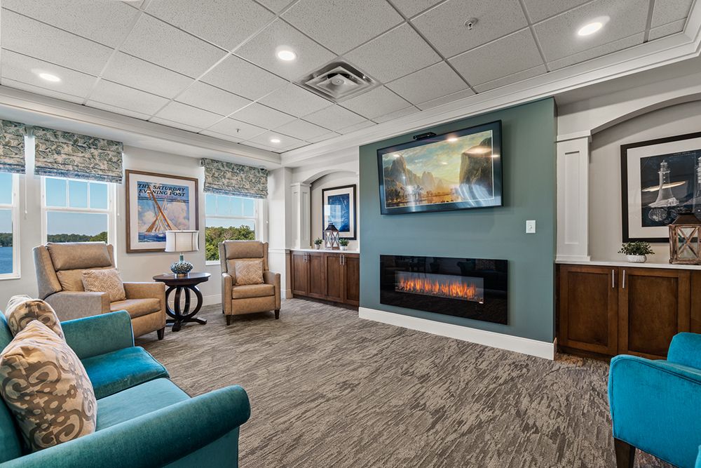 A modern living room with comfortable seating, a mounted television, and a fireplace.