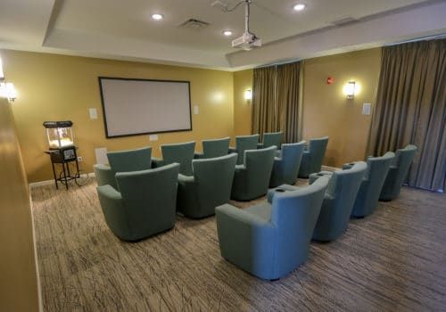 A cozy home theater room with comfortable seating and a large projection screen.