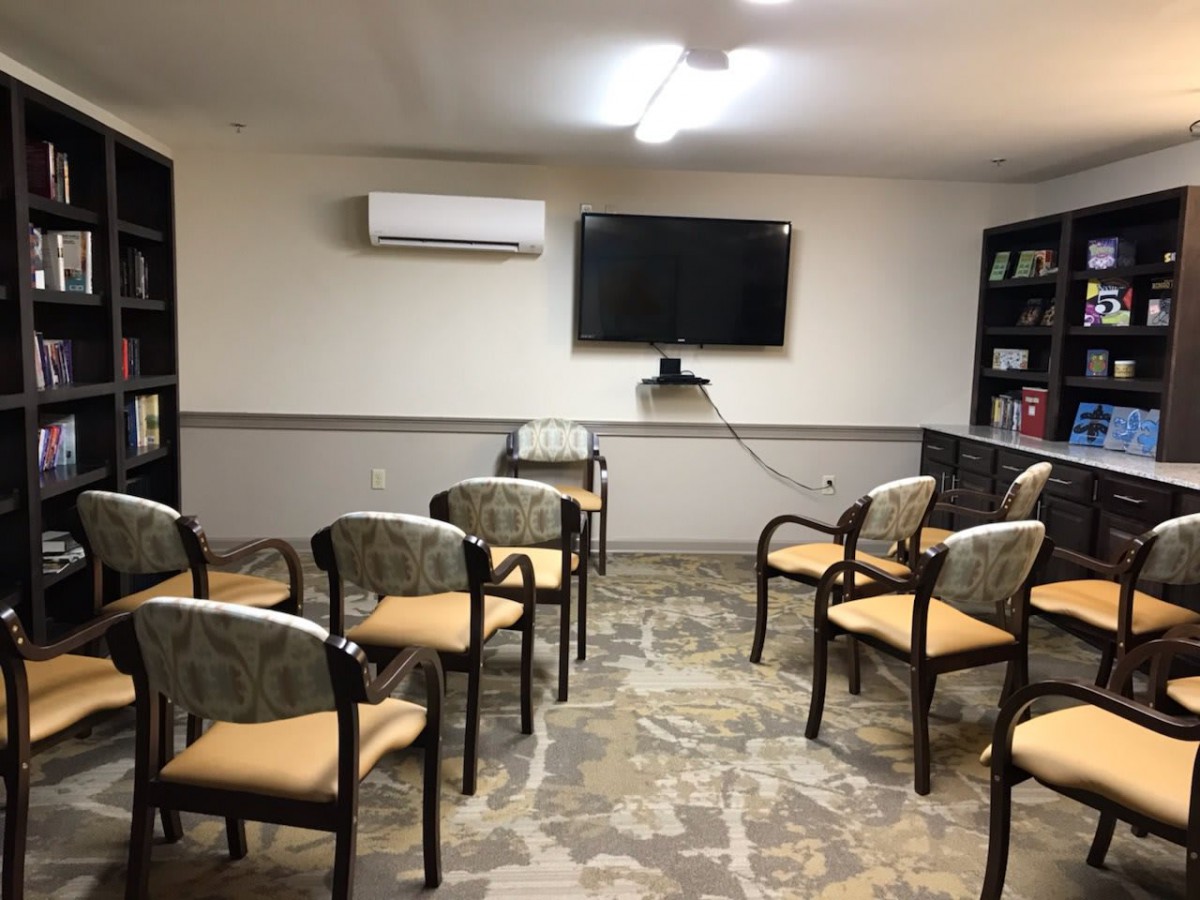 A small meeting room with chairs arranged in rows facing a television screen.
