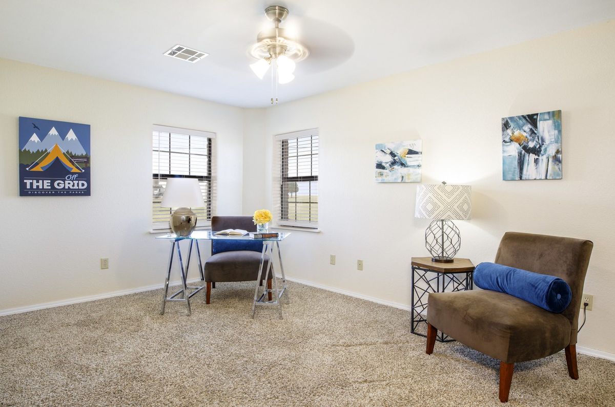 A bright and cozy home office space with a desk, chair, and decorative elements.