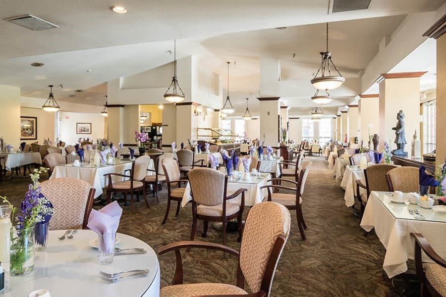 An elegant restaurant dining room with neatly arranged tables and chairs, ready for guests.