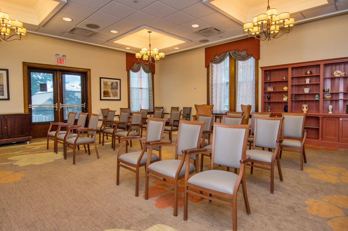 An empty conference room with multiple chairs arranged for a meeting.