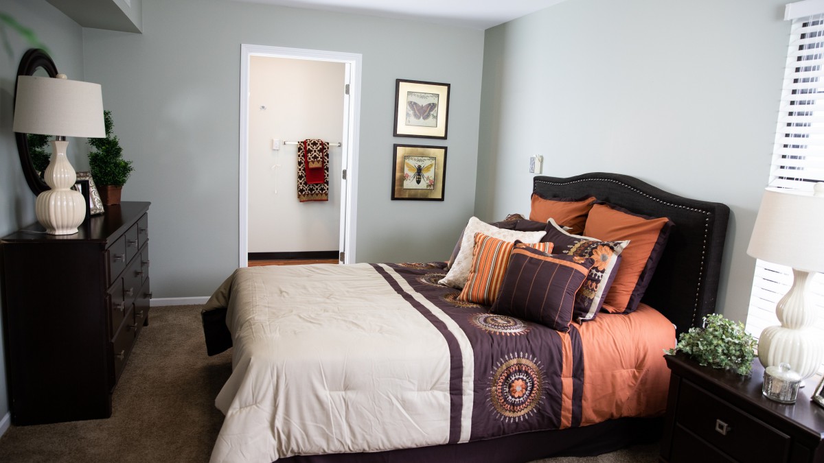 A cozy bedroom with colorful bedding and wall art.