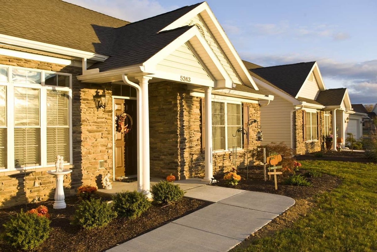 A suburban house with a stone facade and well-maintained front yard.