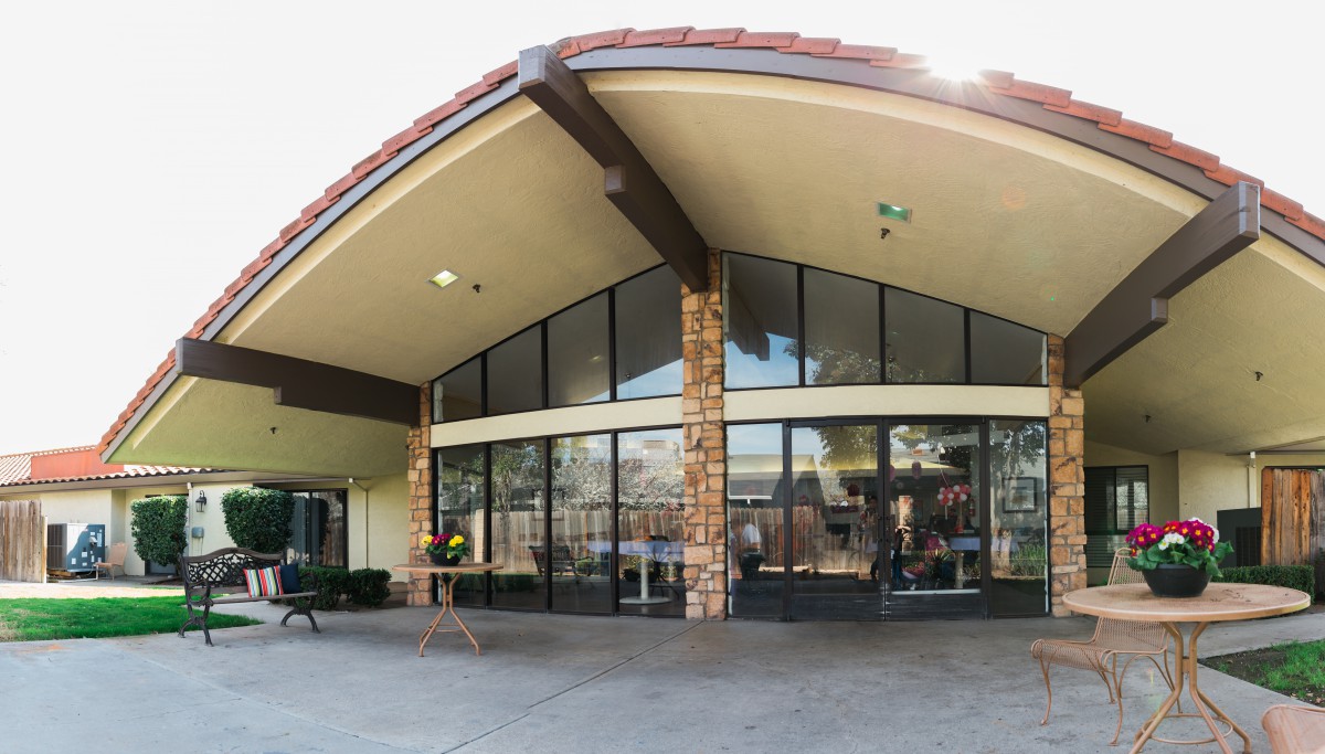 A modern commercial building with large glass windows and stone accents at the entrance.