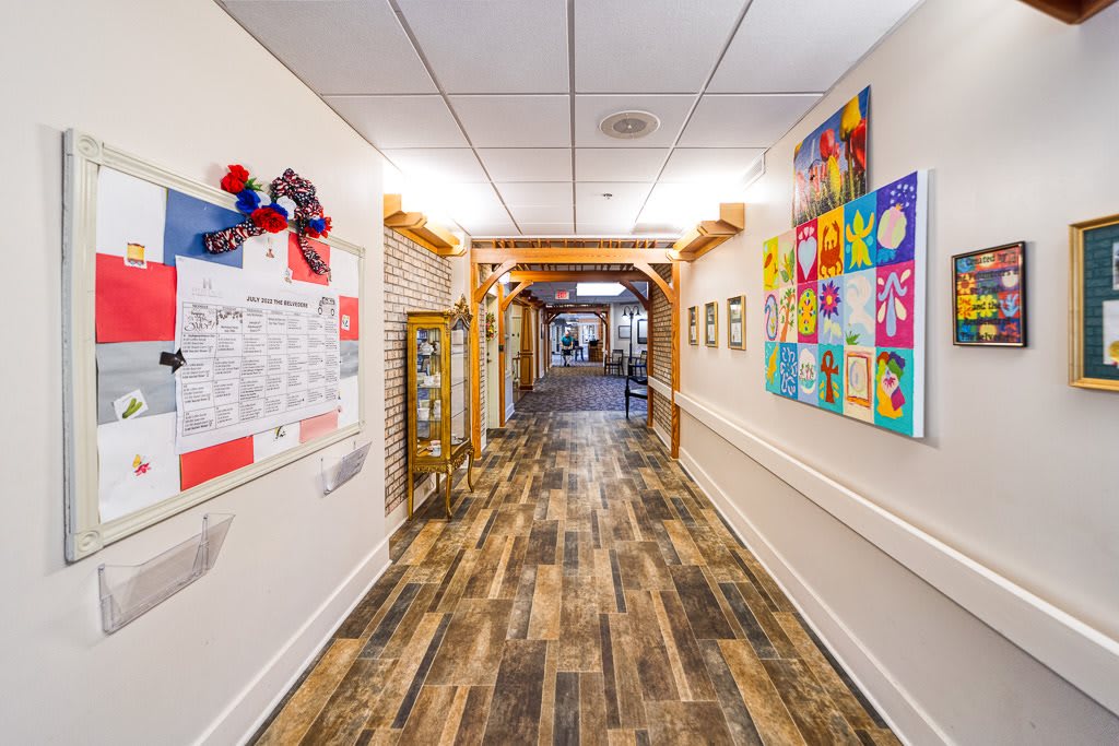 A vibrant hallway adorned with colorful artwork and wooden flooring.