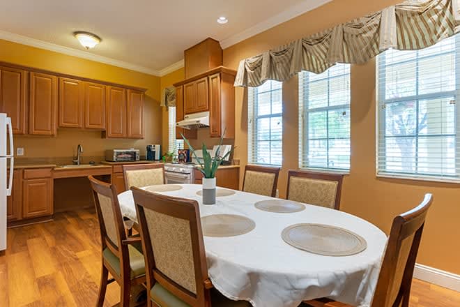 A cozy kitchen and dining area with wooden cabinets and a table set for four.