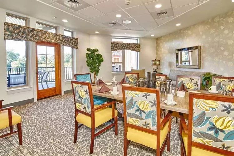 A cozy dining room with colorful chairs and a well-set table in a bright, inviting space.