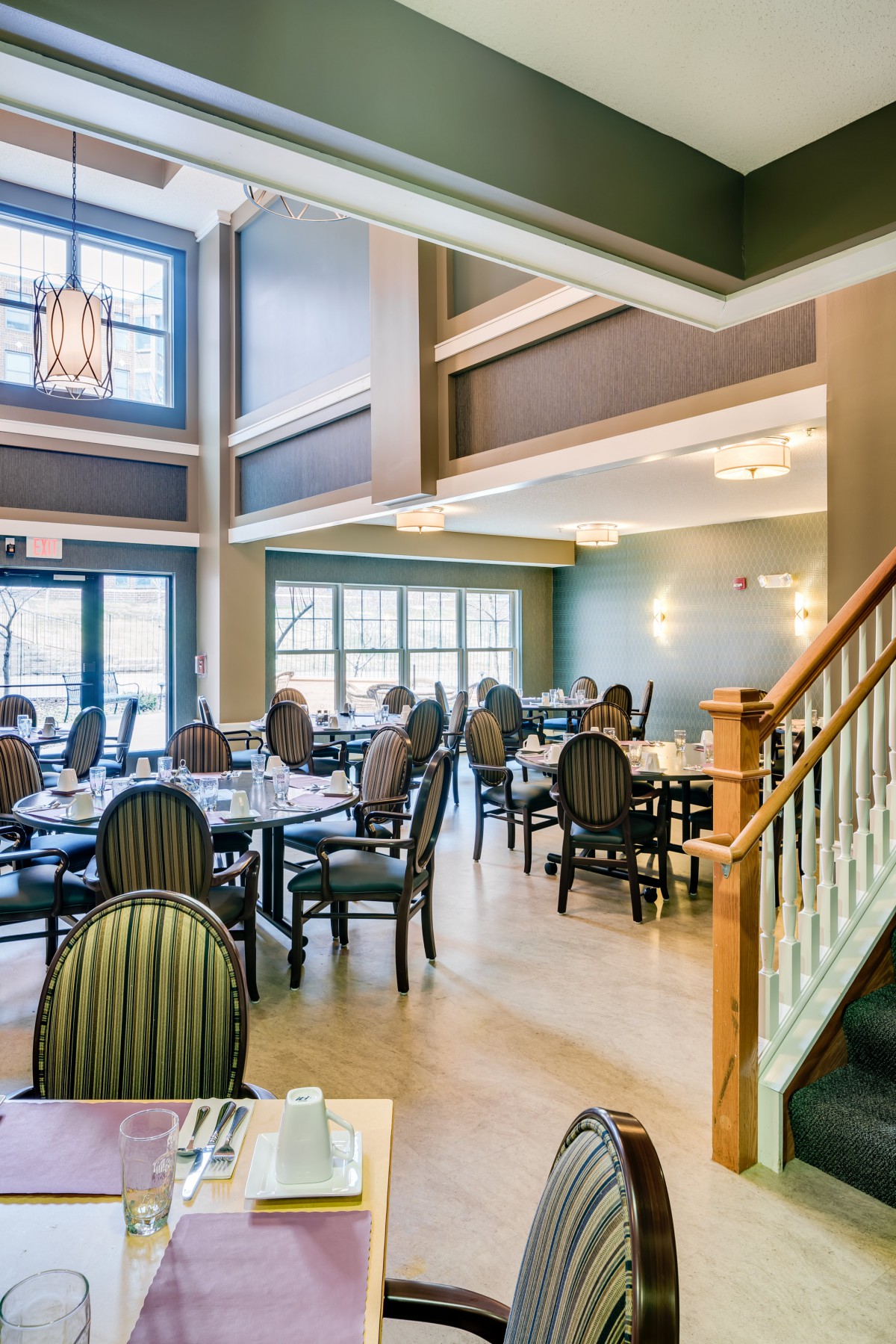 A spacious and elegantly designed restaurant interior with neatly arranged tables and chairs.