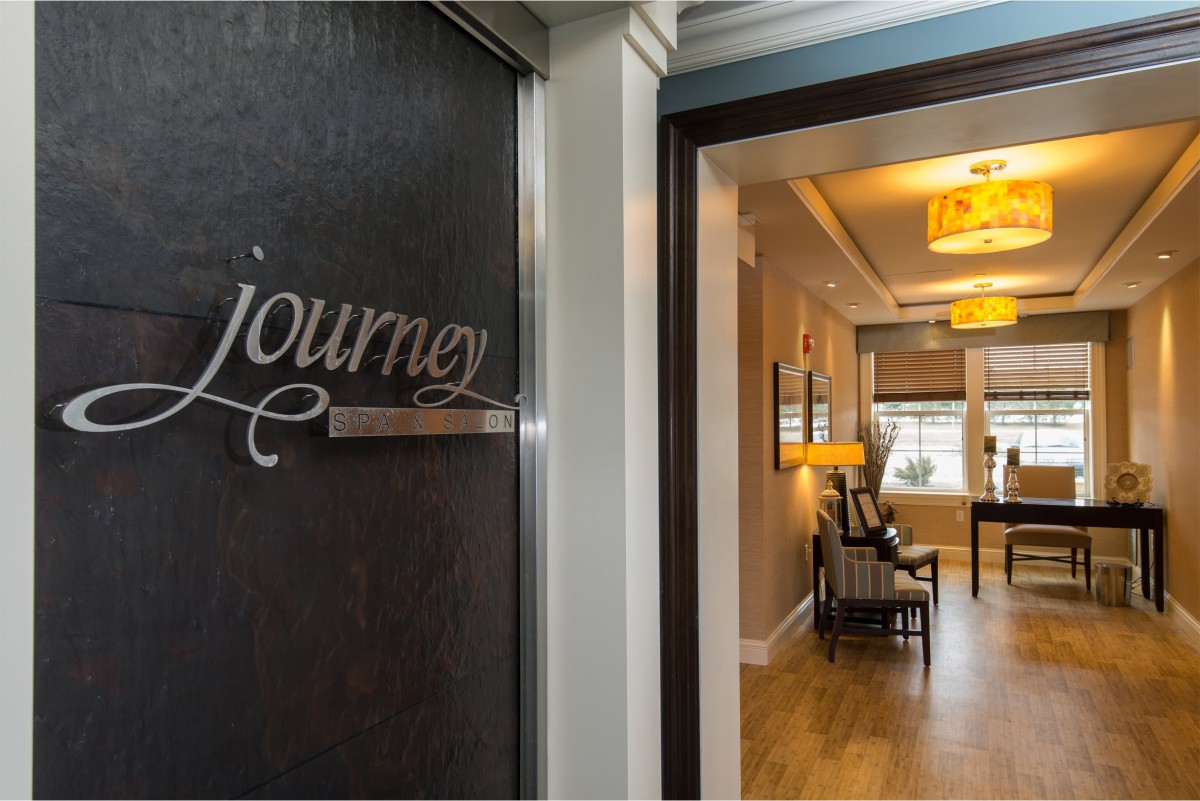 A warmly lit hallway leading into a cozy interior space, marked with the word 'journey' on the door.