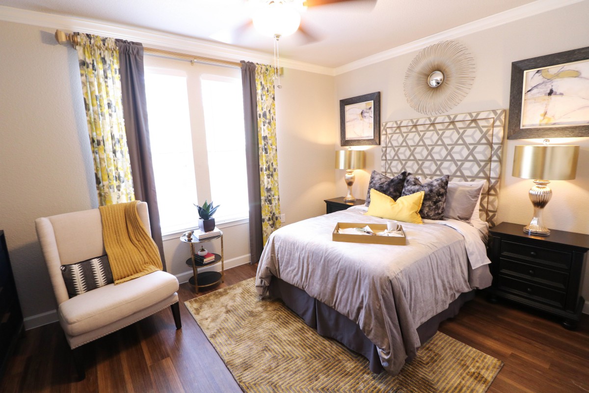 A cozy and stylishly decorated bedroom with a patterned headboard, plush bedding, and accent pillows.