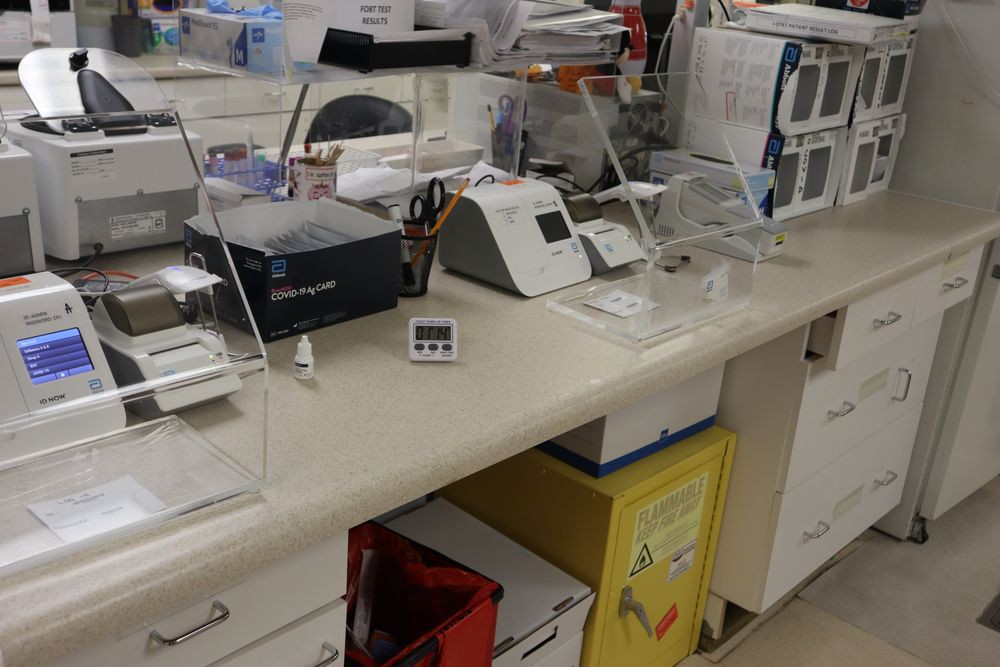 A laboratory workspace with various medical equipment and tools on a countertop.