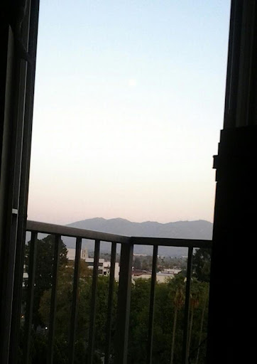 A serene view from the balcony, showcasing distant mountains and a peaceful sky.