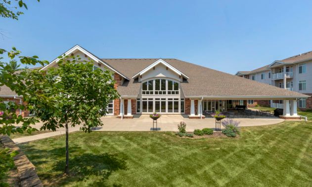 A large suburban house with a well-maintained lawn under a clear blue sky.