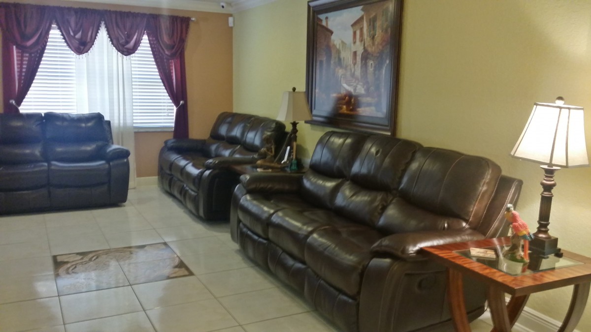 A cozy living room featuring dark leather sofas and elegant decor.