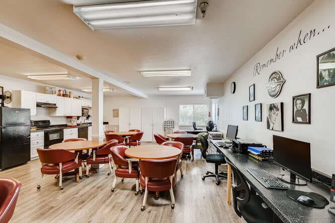 A well-lit classroom equipped with desks, chairs, and computers.