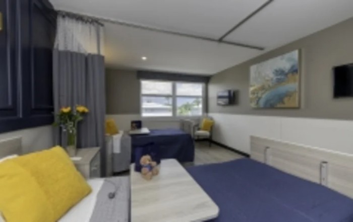 A modern hotel room with stylish furnishings and yellow accent details.