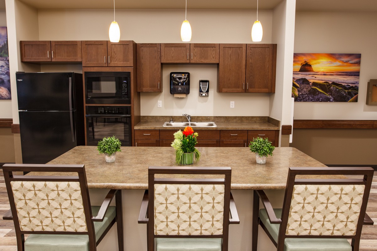 A modern kitchen with wooden cabinets, a central island, and pendant lighting.