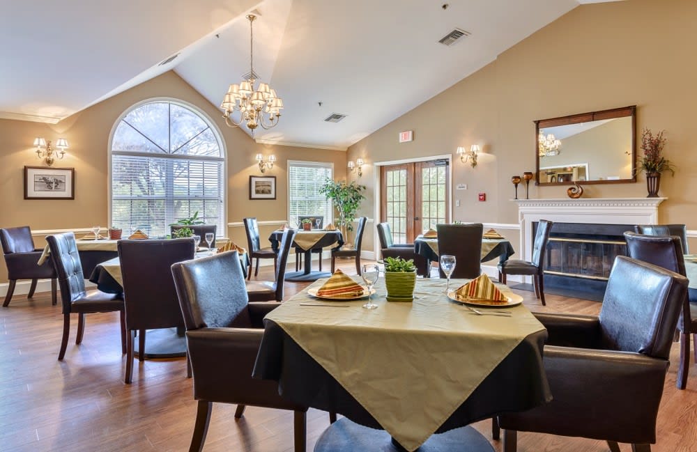 A cozy dining room with elegantly set tables and large windows.