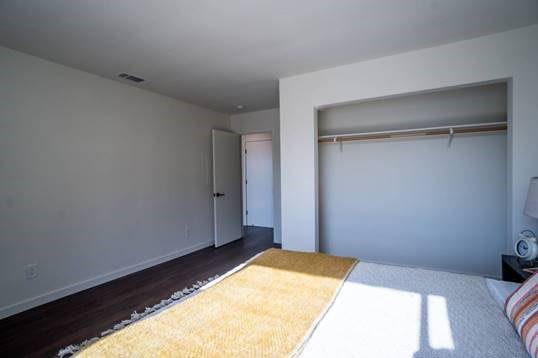 An empty bedroom with a built-in closet and a yellow carpet.