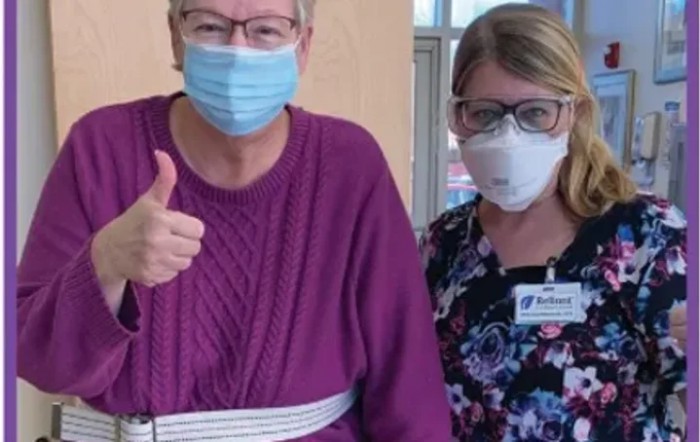 Two individuals wearing masks, one giving a thumbs up.