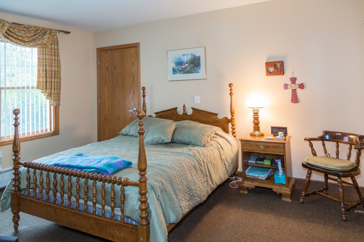A cozy bedroom with wooden furniture and soft lighting.
