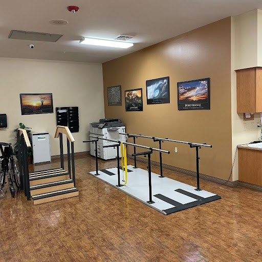 A physical therapy room equipped with exercise equipment and handrails for rehabilitation.