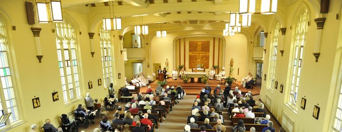 A church service with a congregation gathered in a well-lit interior.