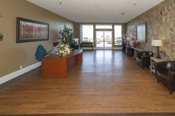 A spacious lobby with wooden flooring and modern decor.