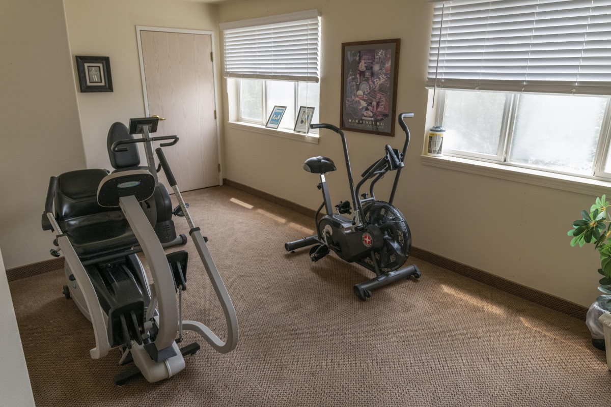 A small indoor gym with cardio exercise equipment.