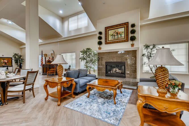 A spacious living room with modern furniture, featuring a central fireplace, a comfortable sofa set, and decorative elements.
