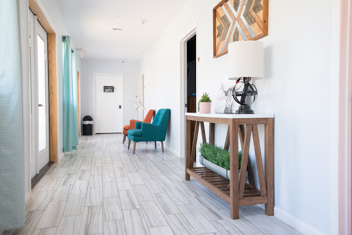 A bright and modern hallway featuring colorful seating and stylish decor.
