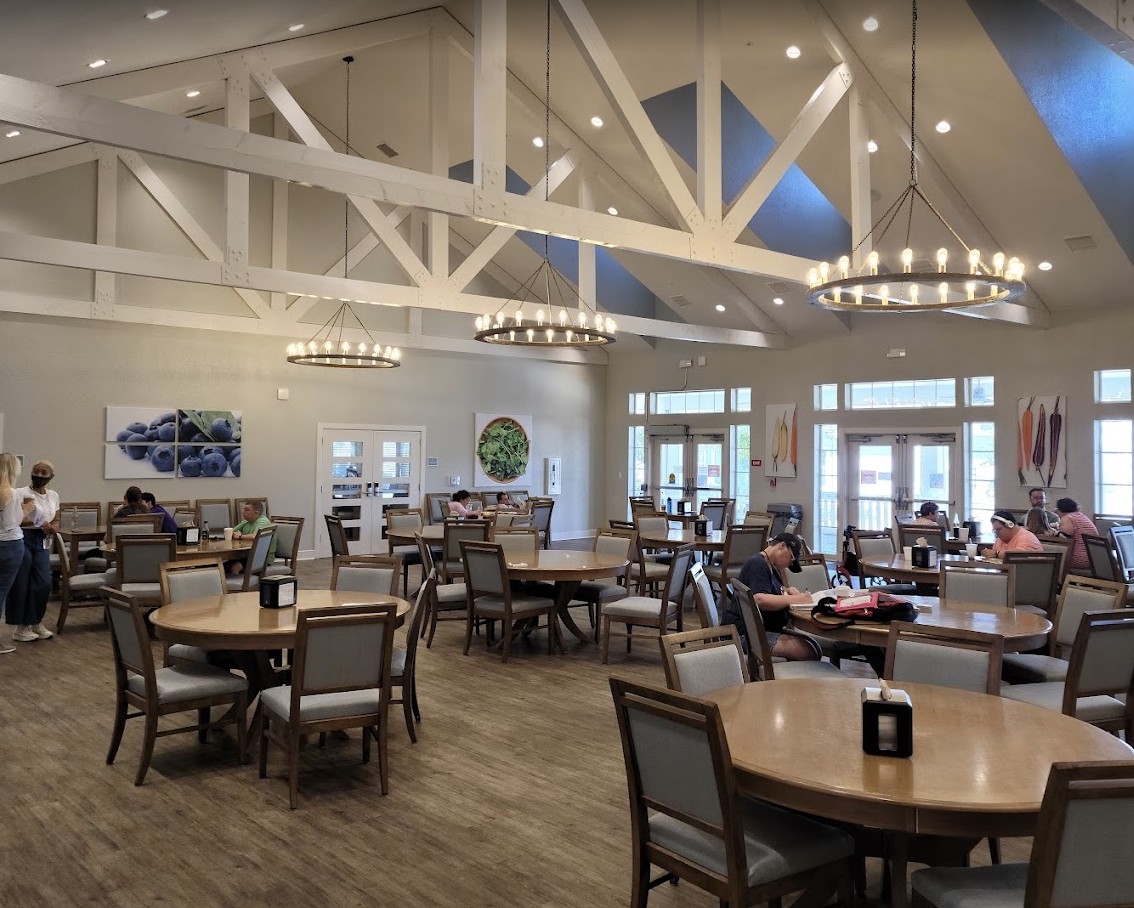 Spacious dining area with elegant lighting and neatly arranged tables and chairs.