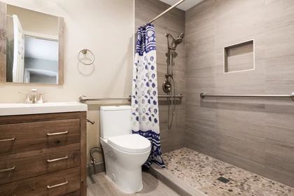 A modern bathroom with a shower, toilet, and sink cabinet.