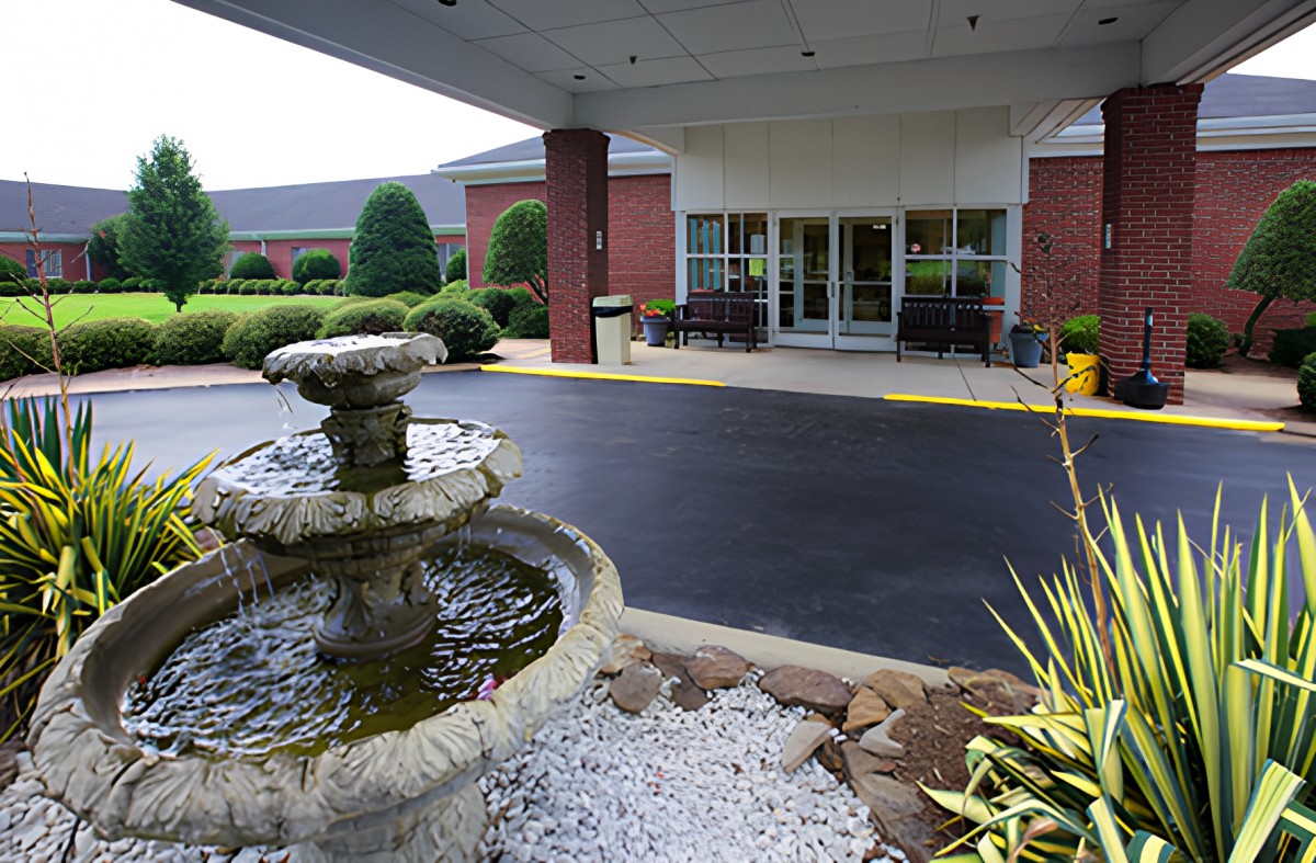 A building entrance with a decorative fountain and well-maintained landscaping.