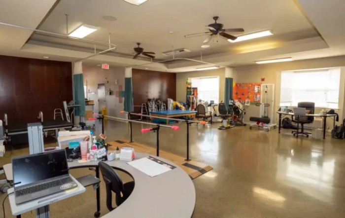 A spacious physical therapy room equipped with various rehabilitation and exercise equipment.