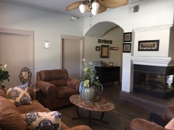 A cozy living room with plush sofas, a central coffee table, and a fireplace adorned with decor.