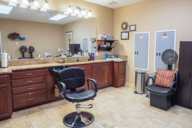 A modern hair salon with styling chair, mirrors, and a well-organized counter.