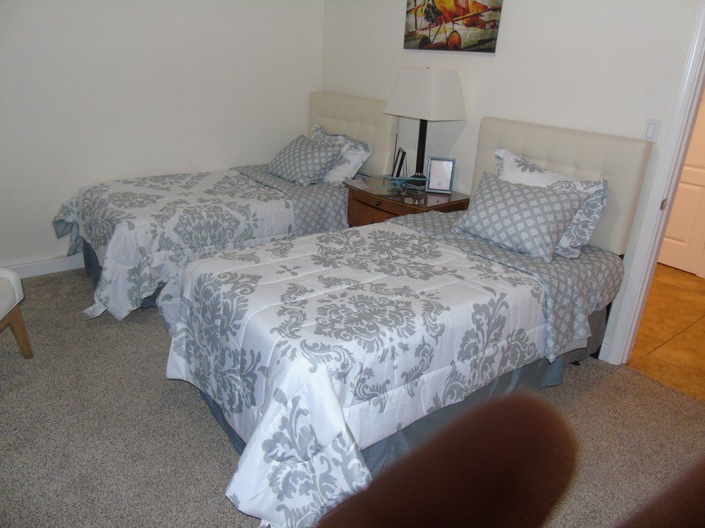 A cozy bedroom with twin beds decorated with patterned bedspreads.