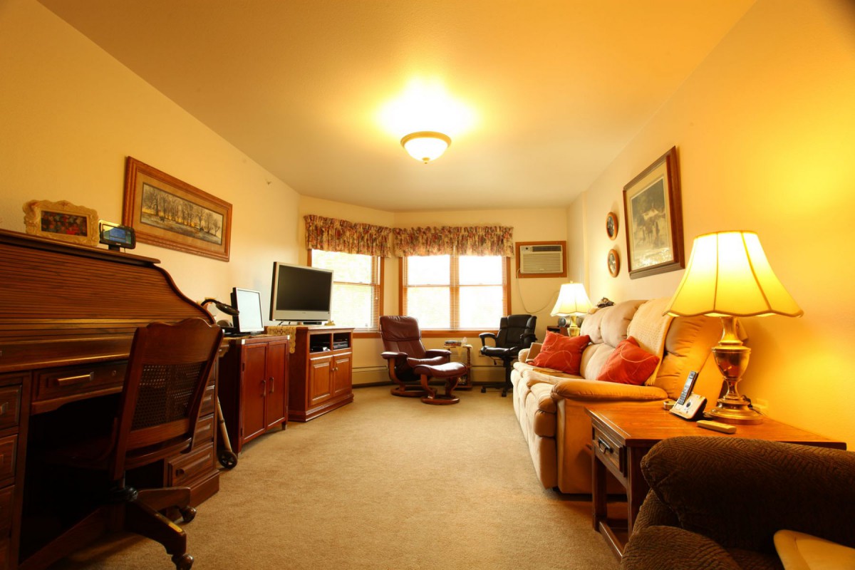 A cozy living room with a sofa, television, and warm lighting.