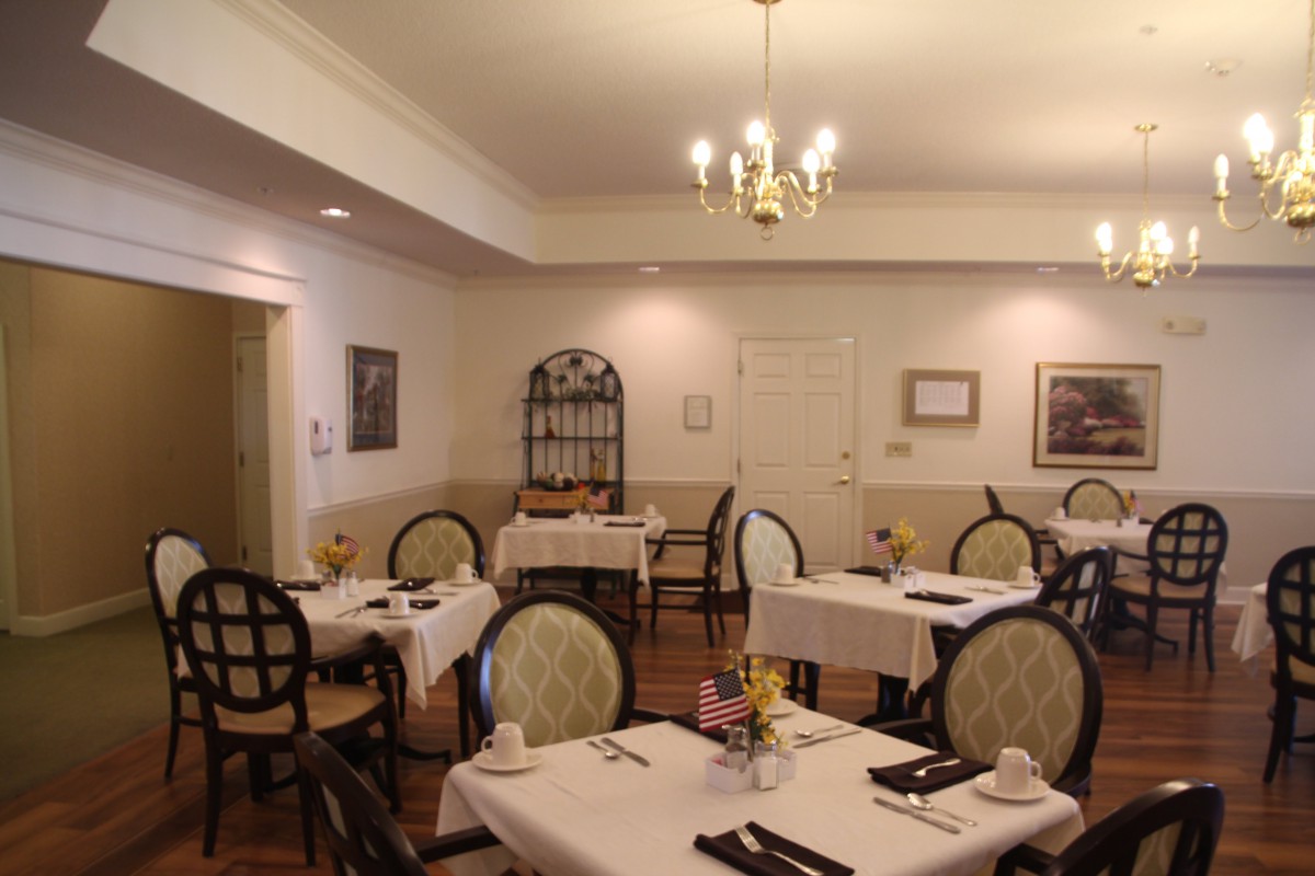 A quiet and elegantly decorated dining room featuring neatly arranged tables and chairs.