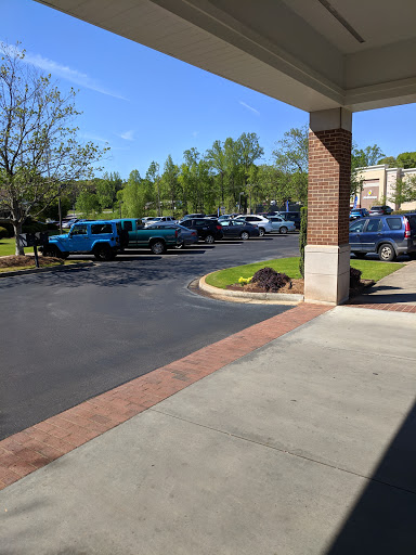 A view of a parking lot with various vehicles under a clear blue sky.