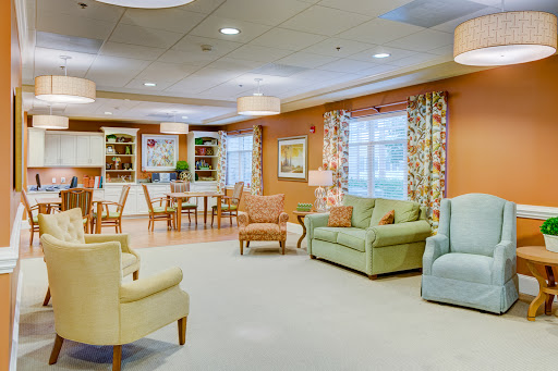 A warm and inviting community living room featuring comfortable seating and cheerful decor.