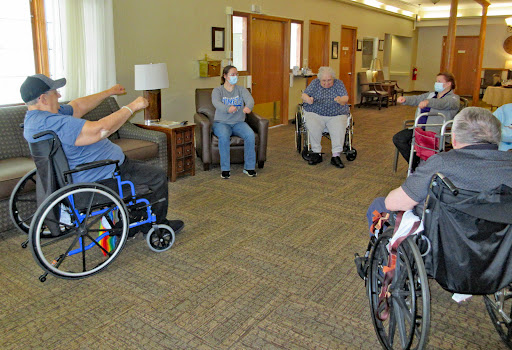 Residents gather for a group activity in a care facility, promoting community and interaction.