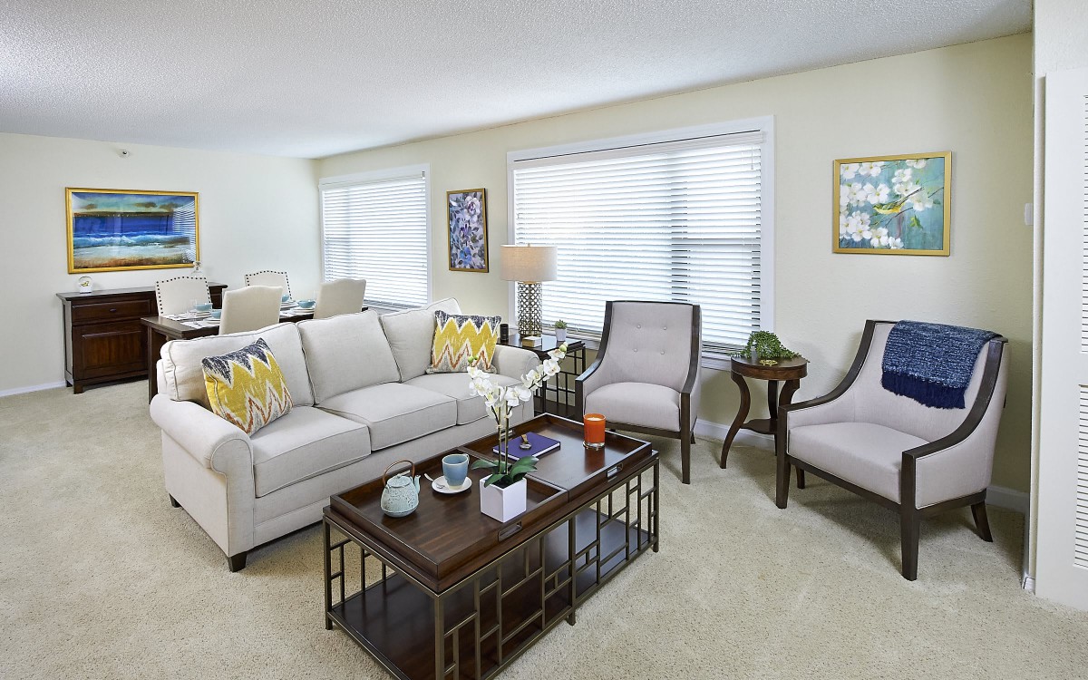 A well-decorated living room featuring a sofa, armchairs, and a coffee table with decorative items.