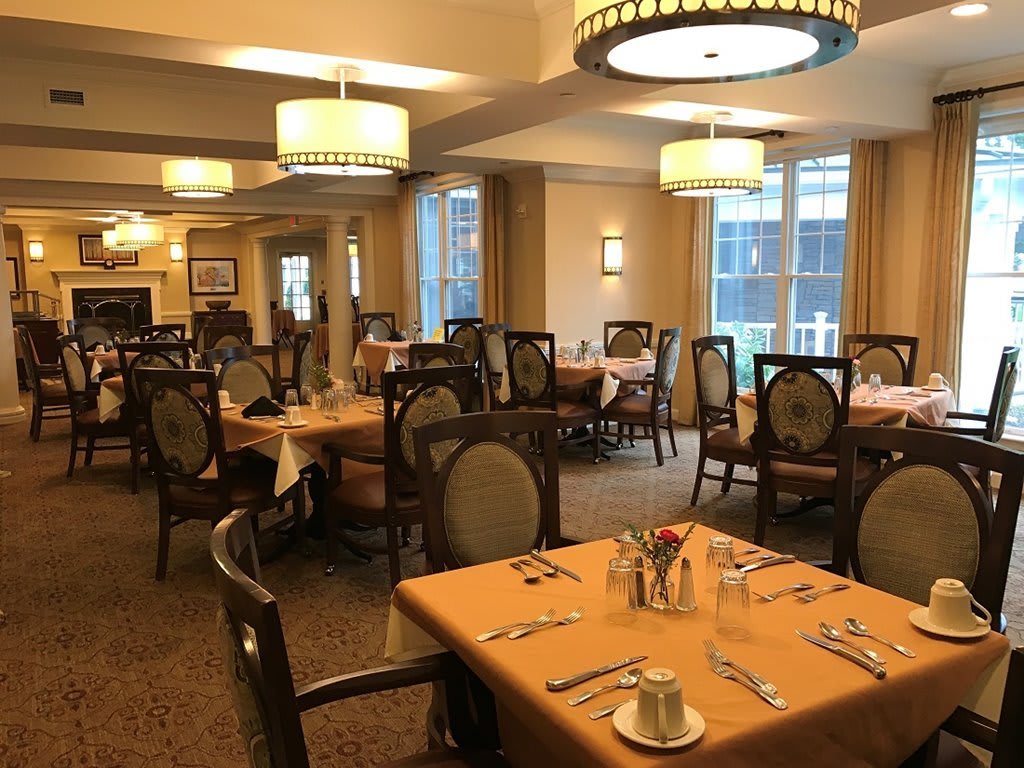 An elegantly arranged dining room with neatly set tables and ambient lighting.