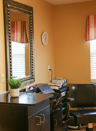 A cozy home office space featuring a mirror, a decorative plant, and warm orange walls.