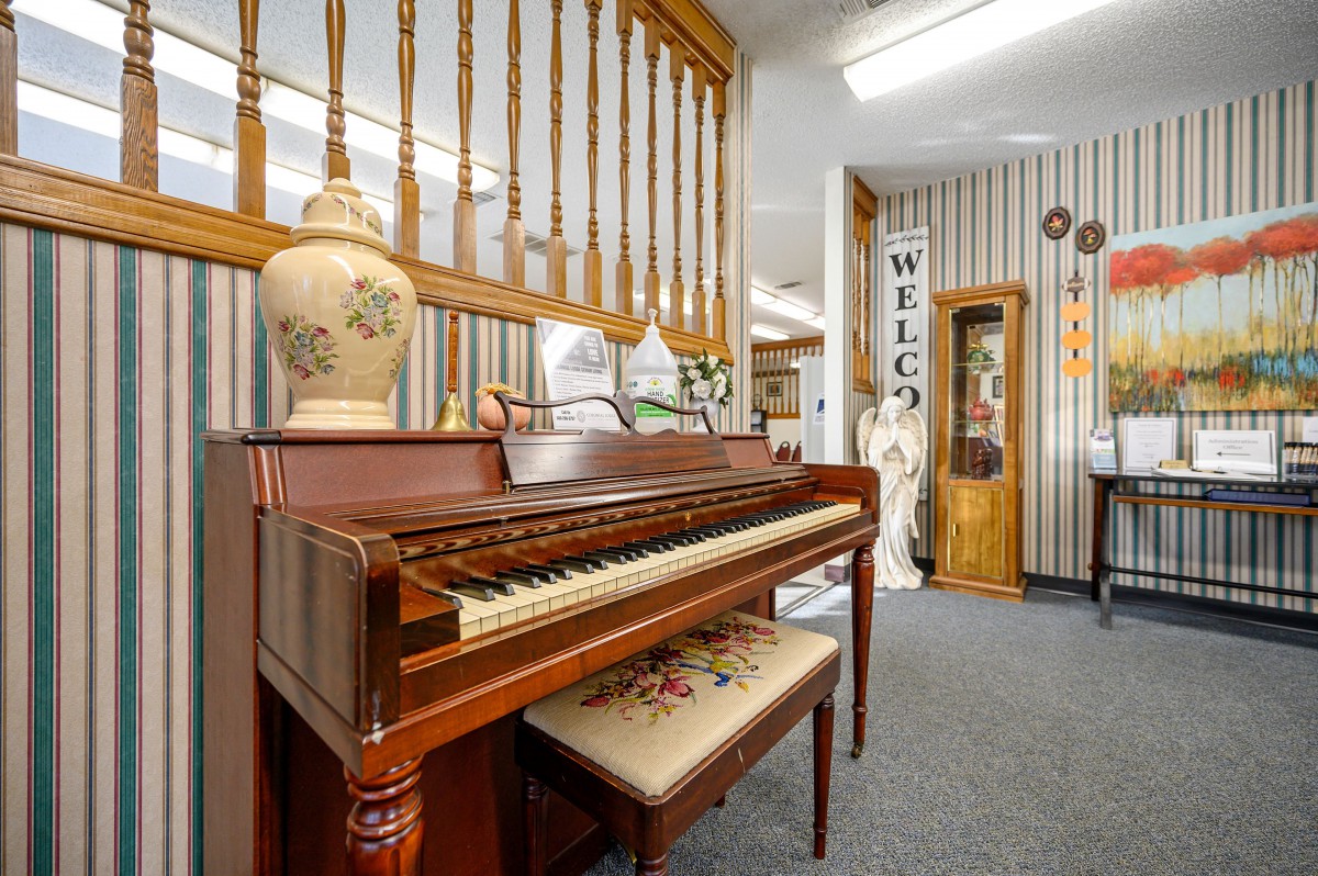 A cozy interior featuring a vintage piano with decorative elements and a welcoming atmosphere.